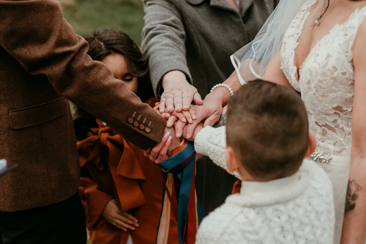 A family hand fasting, all hands in the middle on top of one another