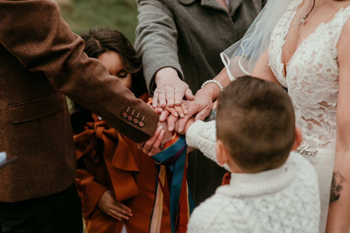 A family hand fasting, all hands in the middle on top of one another