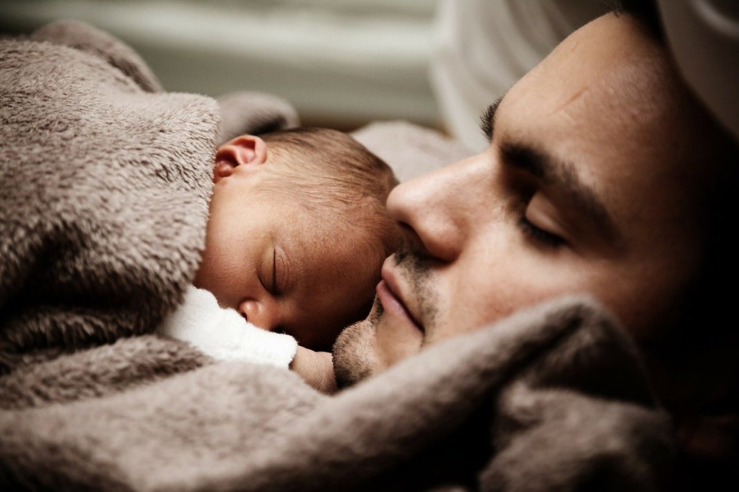 A father snuggles his baby close