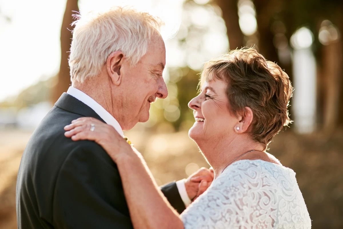 An older couple dance, looking into each other's eyes