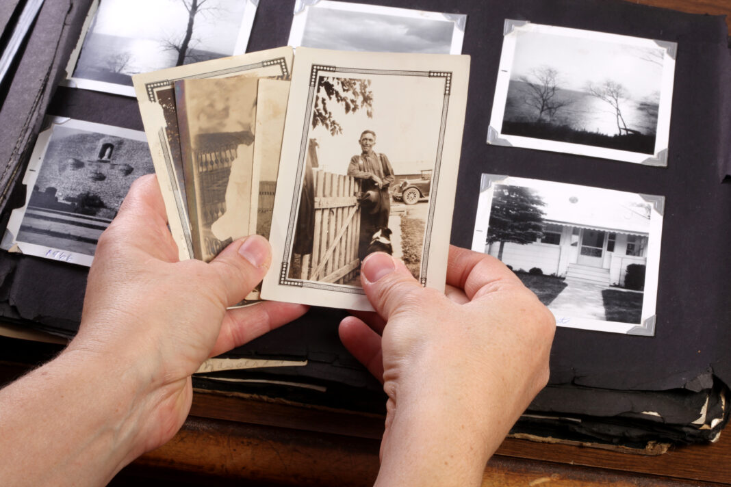 Hands holding old photographs.